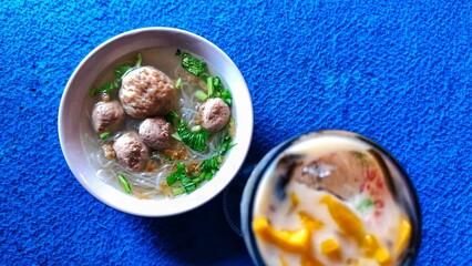 Delicious Indonesian Meatballs in Broth and Refreshing Dessert A Culinary Delight on a Blue Backdrop