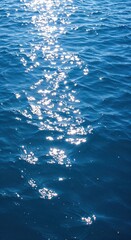Naklejka premium Sparkling Oceanic Radiance: A mesmerizing aerial view of the deep blue ocean with shimmering sunlight dancing on the water surface. This tranquil scene evokes feelings of peace and vastness.