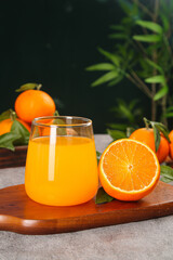 Freshly Squeezed Orange Juice with Fresh Oranges on Wooden Cutting Board
