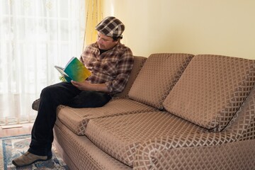 Obraz premium latino man sitting on the sofa reading a book