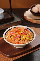 Delicious vegetable fried rice with eggs and colorful ingredients served on wooden board in traditional kitchen