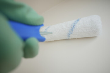 Painting a wall with a roller brush in a clean space