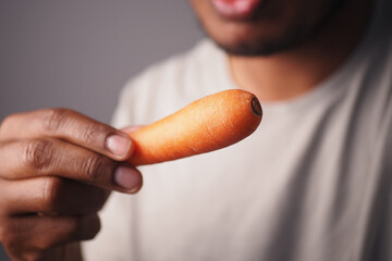 Holding a carrot up close in a casual setting