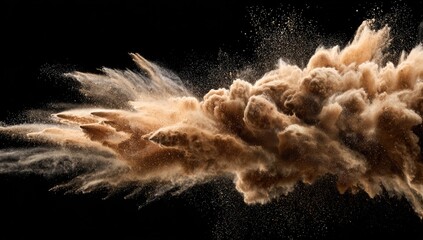 A tan dust cloud explodes against a black background, creating a dynamic, abstract shape with fine particles dispersed throughout the air, exhibiting texture and motion
