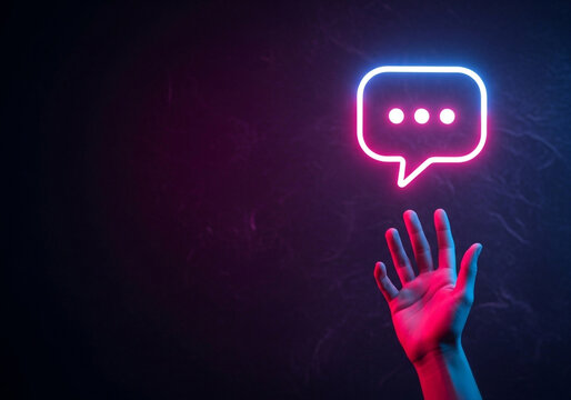 A hand holding a blue neon chat bubble with ellipses, an image perfect for illustrating an ongoing conversation, live chat, or waiting for a reply