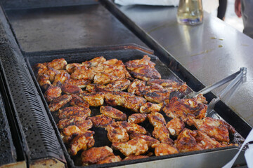 Grilling seasoned chicken at a lively outdoor event