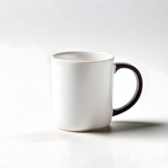 Obraz premium A simple white ceramic coffee mug with a dark handle sits isolated on a bright white surface with soft shadows.