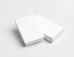 Two plain white rectangular boxes, unbranded and clean, resting on a light gray surface, ideal for product packaging mockups.