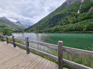 Fototapeta premium Emerald green lake surrounded by beautiful mountains