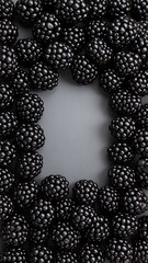A vibrant cluster of ripe blackberries, glistening with dew, showcases their deep purple-black hue, nestled among lush green leaves in a sunlit garden.