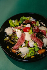 Tuna tataki salad fish food dish on a black plate. Japanese food 