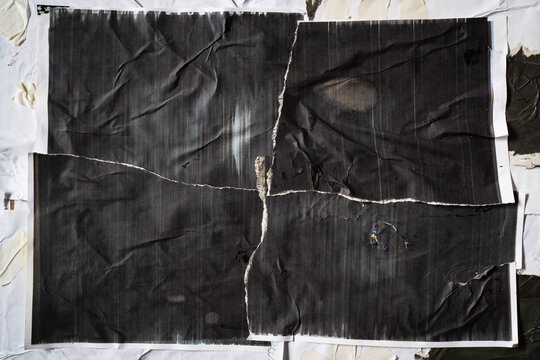Badly printed black paper was torn into 4 parts and glued to a wall