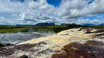 Scenic View from Top of Waterfall with Table Mountain and Plains Under Blue Sky