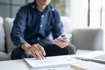 Man calculate finances home pay bills taxes on mobile phone and calculator financial at home