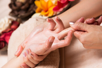 若いアジア人女性はハンドマッサージを受けている。