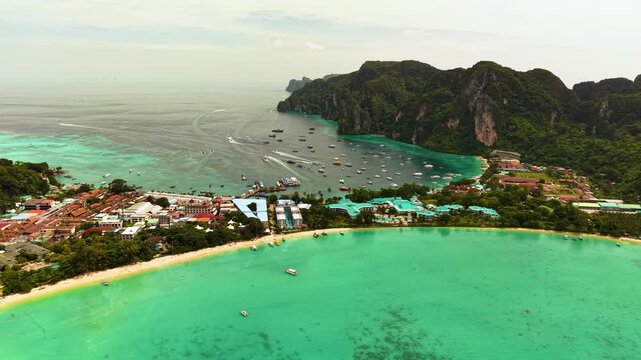 Scenic aerial drone shot of Phi Phi Islands lagoon with boats floating in clear turquoise waters.
