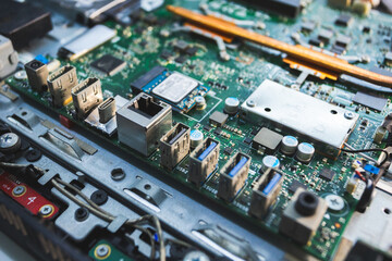 Close-up image of an all-in-one computer interior showing the motherboard, heat pipe cooling system, RAM slot, processor, and electronic components. Inside View of All-in-One Computer Motherboard