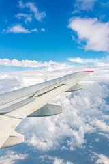 View from the airplane window at a beautiful cloudy sky and the airplane wing