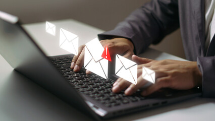 Email Communication and Online Notification: An individual skillfully uses a laptop in a modern setting, with floating digital email icons signifying the modern era of communication.
