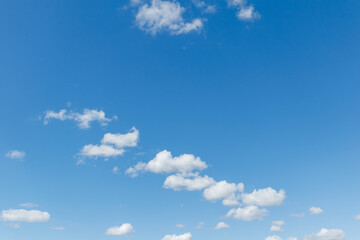 Clear blue sky with scattered white clouds