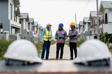 Construction engineers walking through residential development site to inspect and coordinate...
