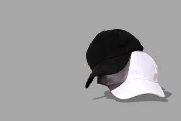 Three caps in black, gray, and white are arranged artistically