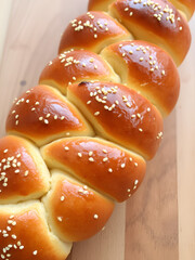 Golden braided challah bread with sesame seeds, a delicious homemade treat ready to enjoy