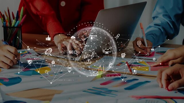A diverse team collaborating on a marketing strategy using a laptop and colorful graphic templates, illustrating modern teamwork and digital innovation in the office environment. Raster