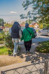 Young women walk along the sidewalk on an autumn day
