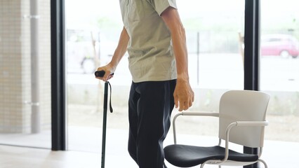 杖をついて立ち上がるアジア人高齢者