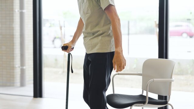 杖をついて立ち上がるアジア人高齢者