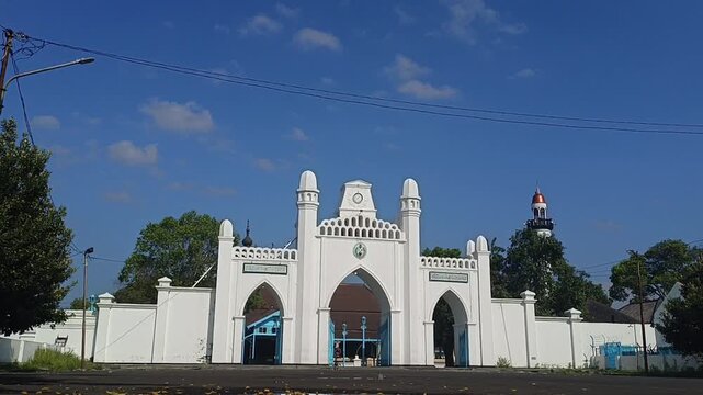Surakarta, Central Java, Indonesia, September 6, 2025. Timelapse Historic gate of Masjid Agung , Colonial-style arches, local crowd, sunny day. Cultural heritage, religion, travel, Southeast Asia.