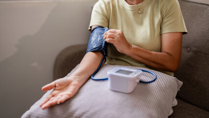 Older woman blood pressure check home vital signs management preventative health wellness routine self care monitoring