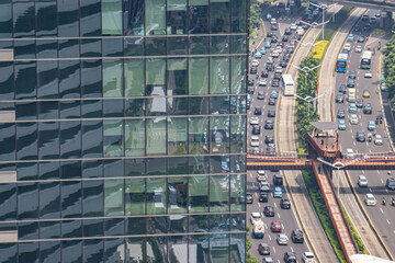 Vehicles are stuck in traffic jams during the day on a main road in the middle of the city.