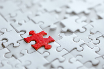 Fototapeta premium Nearly completed white jigsaw puzzle with one unique red piece in center, symbolizing individuality and uniqueness with high contrast lighting