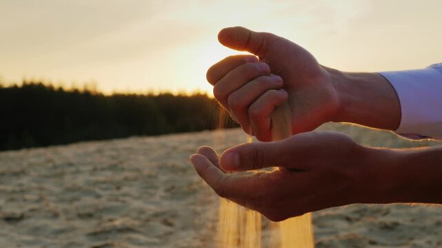 Sands slip through the hands of man in a suit  4k video