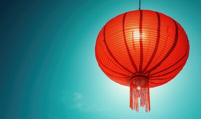 A vibrant red Chinese lantern hangs against a clear cerulean sky