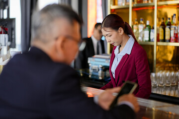 Attractive saleswoman, cashier serving customers at a retail store counter or bar restaurant counter.	