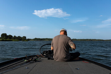 Man seated on boat preparing fishing gear on the lake
