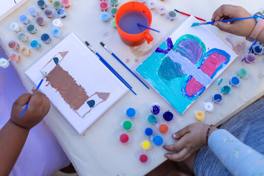 Two biracial girls painting pictures on a playdate