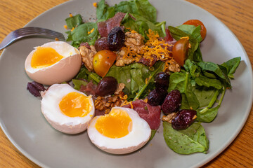 Boiled eggs with spinach, nuts, tomatoes, cheese, seasoned with pepper and salt and drizzled with olive oil.
