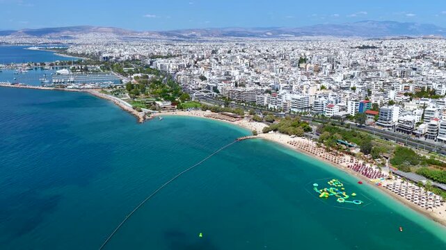 Panoramic aerial view of the coast of Athens, Greece, with Alimos district, public beaches and yacht marinas next to the urban skyline