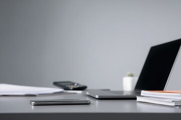 close-up of a desk in an office with documents, a laptop, and a phone on it, against a gray background, minimalistic style.