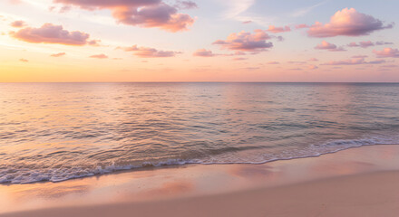 Obraz premium Calm Ocean Beach at Sunset with Pink Clouds and Sandy Shoreline