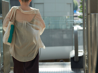 夏の朝の都市のビジネス街で歩く女性会社員の姿