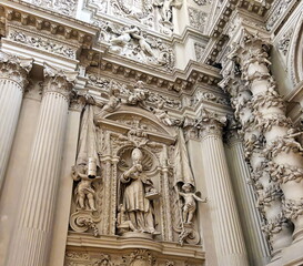 A view from below of the amazing masterpieces of sculptural art and stone carving art that decorate the premises of the Theatinerkirche with angels, archbishops and saints.