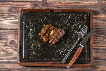 Meatball with grilled cheddar on stone cutting board in steakhouse restaurant