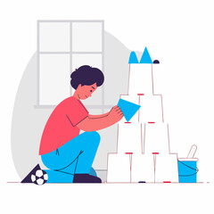 Young boy building a tower with plastic cups indoors by a window  
