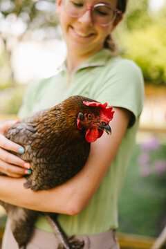 Close up of hen that young teen girl is holding and smiling