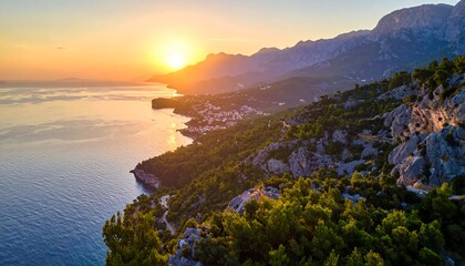 Dramatic coastal scenery at sunset, featuring a rugged coastline, lush greenery, and a vibrant sky.